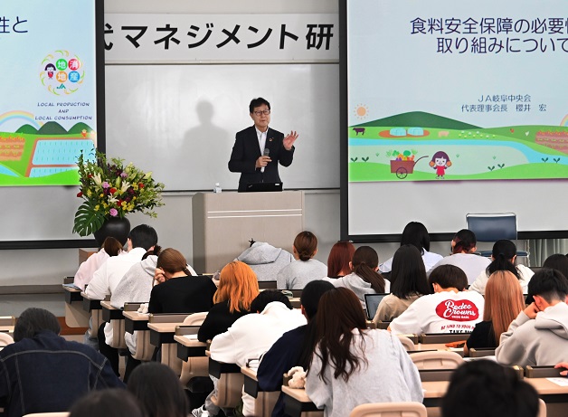 豊富なスライド資料を投影して講演するぎふ農業協同組合の櫻井宏会長