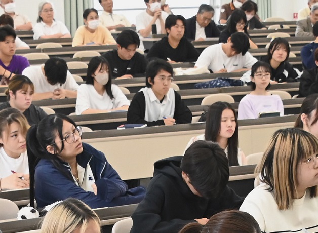 講義を聴いて熱心にメモを取る学生たち